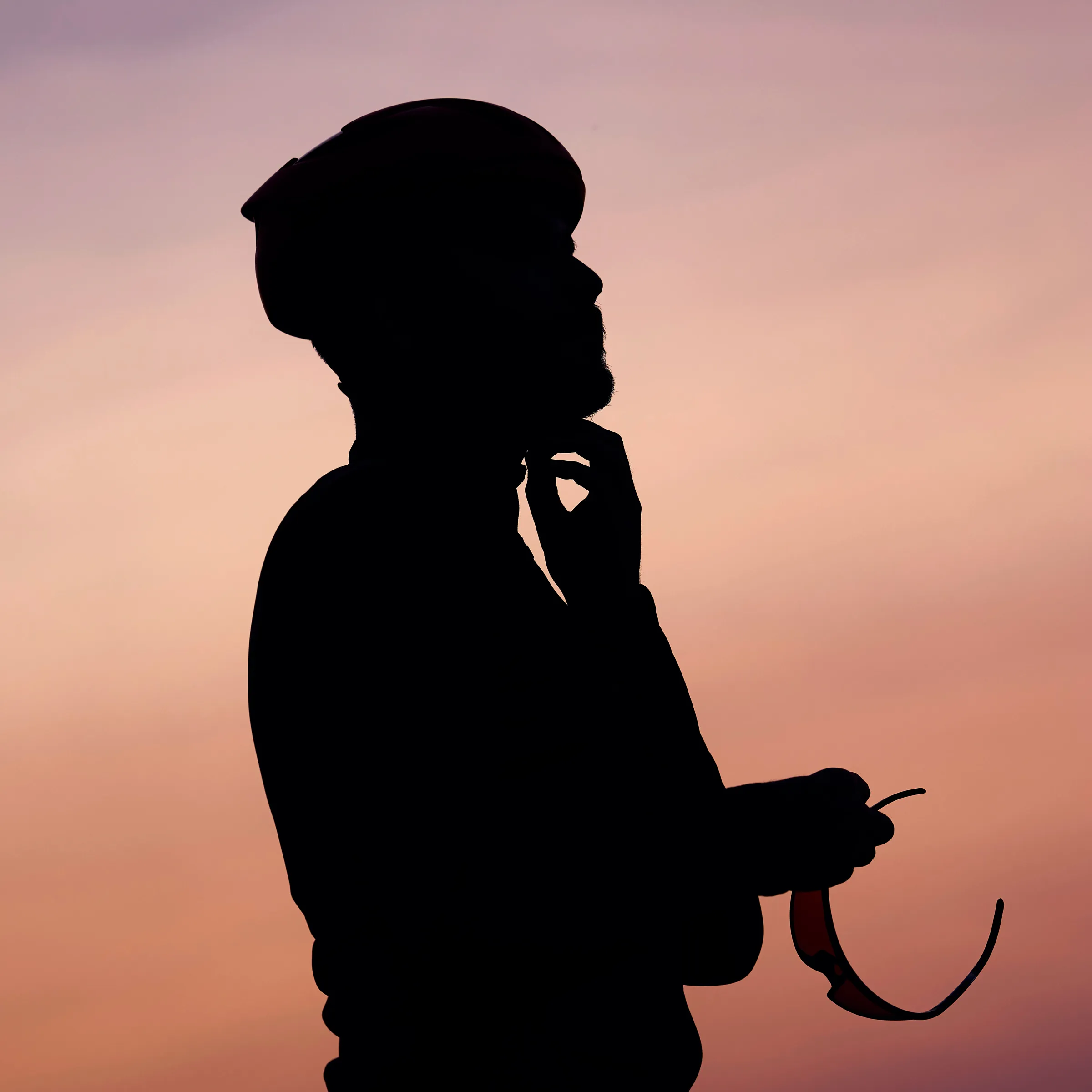 Silhouette of a cyclist unfastening their helmet